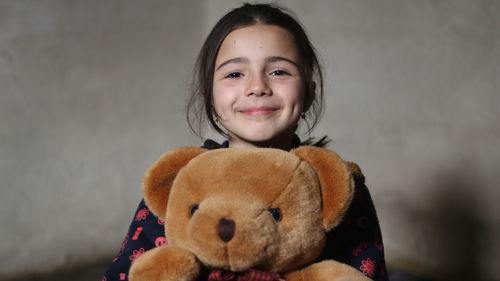 Portrait of smiling girl against wall