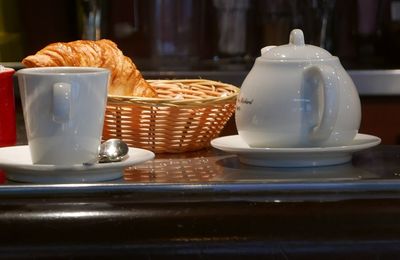 Close-up of french breakfast with coffee served on table at sidewalk cafe