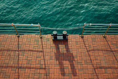 High angle view of railing by sea