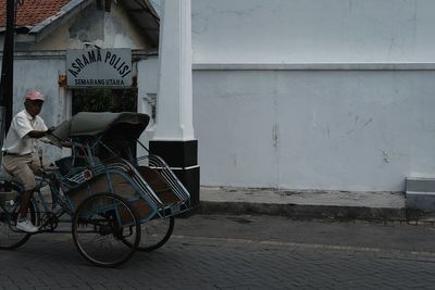 Bicycle parked against building in city