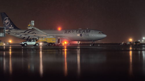 Illuminated airport runway against sky at night