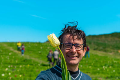 Portrait of smiling boy on field against blue sky