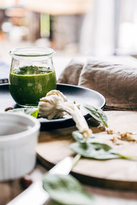 Close-up of green pesto sauce served in glass on table