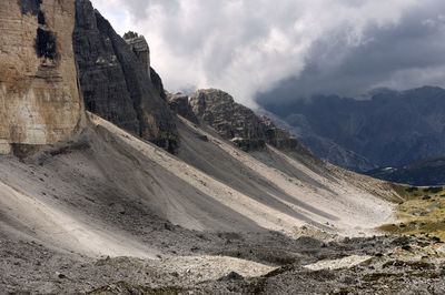 Cropped rocky mountains against clouds