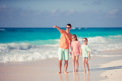 Woman standing at beach against sky