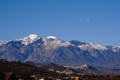 Scenic view of snowcapped mountains against clear blue sky