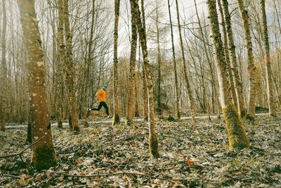 Man running on plants in forest