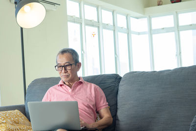 Man using mobile phone while sitting on sofa