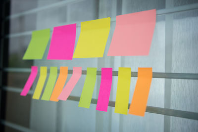Close-up of blank adhesive notes hanging against window