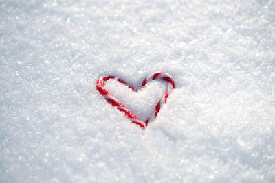 Valentines day, love, romantic web banner with red candy heart on white snow. valentines day