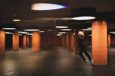 Woman jumping in illuminated garage