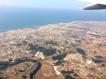 Aerial view of city by sea against sky