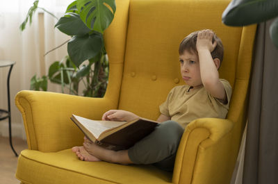 Portrait of young woman sitting on sofa at home