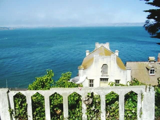 sea, horizon over water, water, built structure, architecture, blue, railing, sky, building exterior, nature, day, tranquility, beauty in nature, scenics, house, protection, tranquil scene, outdoors, no people, sunlight