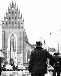 Rear view of man standing in front of temple