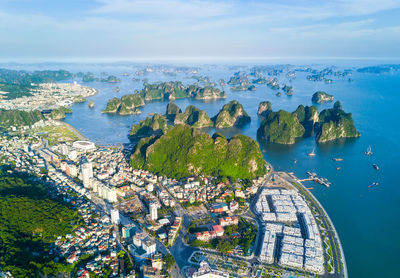 High angle view of cityscape by sea against sky