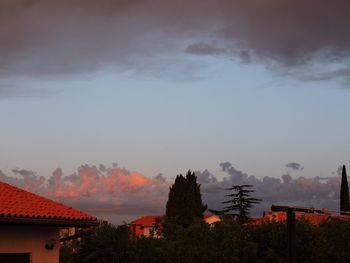 Houses and trees against sky during sunset