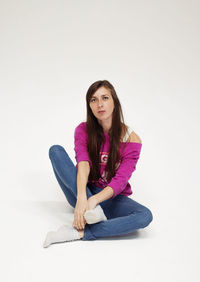 Portrait of young woman standing against clear sky