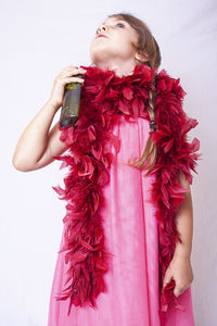 Midsection of woman holding red while standing against white background