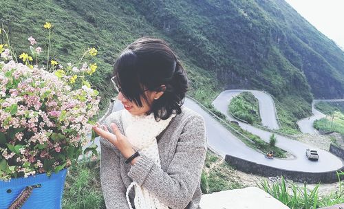 Woman standing by plants against mountain