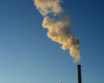 Low angle view of smoke stack against sky