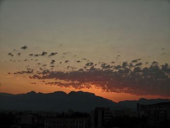 Scenic view of silhouette buildings against sky at sunset