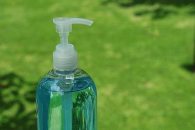 Close-up of glass bottle on field