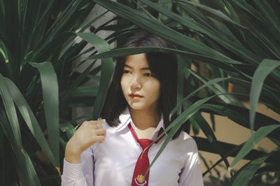 Teenage girl looking away amidst plants