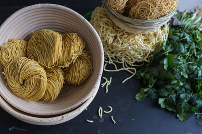 High angle view of dry noodles with parsley on table