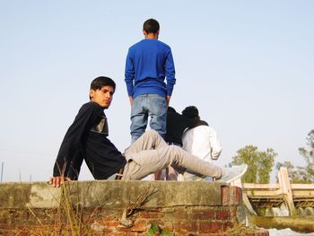 Low angle view of boys against clear sky