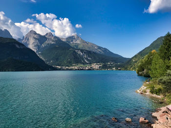 Scenic view of sea and mountains against blue sky