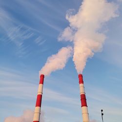 Low angle view of smoke emitting from chimney against sky