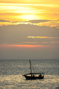 Silhouette boat in sea against sky during sunset