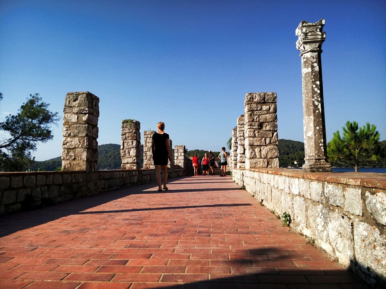 architecture, built structure, building exterior, clear sky, the way forward, history, copy space, blue, famous place, travel destinations, travel, sunlight, city, tourism, tower, international landmark, day, monument, walkway, diminishing perspective