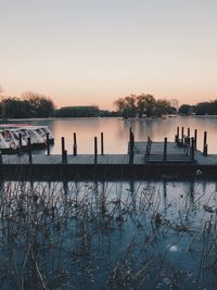 Silhouette people by lake against clear sky during sunset