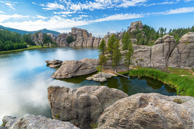 Scenic view of lake and rock formations against sky