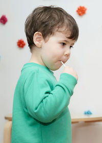 Cute baby boy enjoying a lollipop at home
