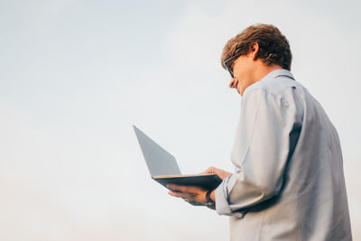 Smiling young businessman with laptop