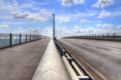 Road by bridge against sky