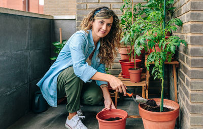 Portrait of smiling young woman standing in yard