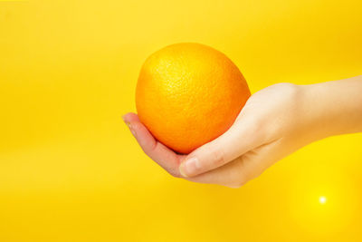Cropped hand holding orange