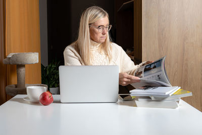 Mid adult woman using laptop on table