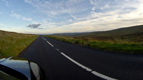 Road passing through landscape against sky