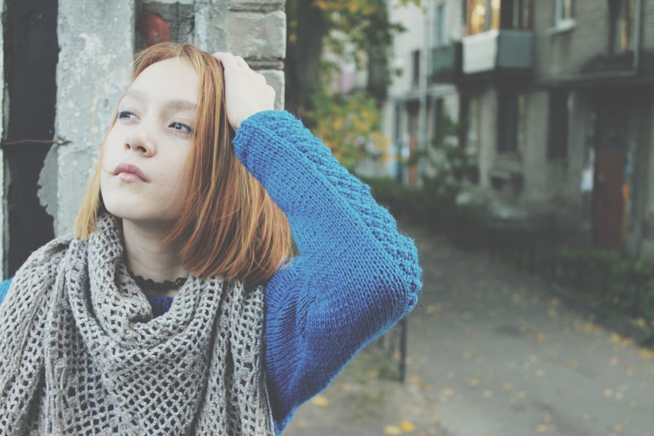 person, lifestyles, casual clothing, focus on foreground, leisure activity, long hair, young adult, portrait, young women, front view, looking at camera, headshot, building exterior, standing, waist up, smiling, built structure, warm clothing