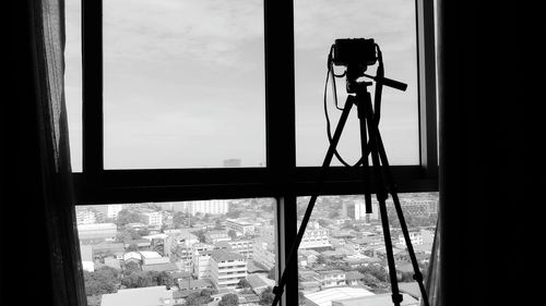 Silhouette of man photographing through window