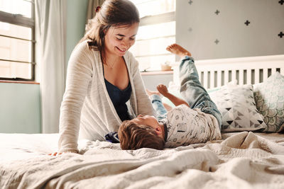 Mother and son playing on bed