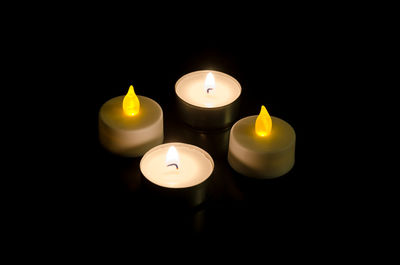 Close-up of lit candle against black background