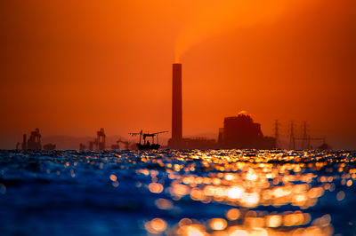 Illuminated city against sky during sunset