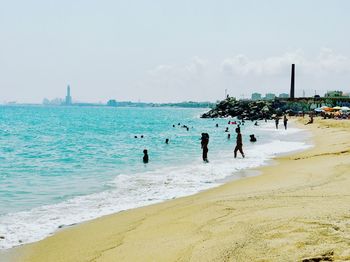 People on beach against sky