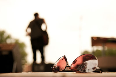 Close-up of man with sunglasses standing against sky